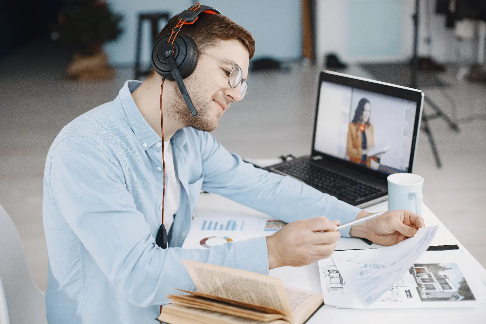 Estudiante en una clase de español online, con auriculares y apuntes